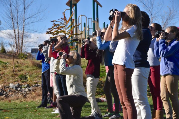 Student group using binoculars to participate in citizen science.