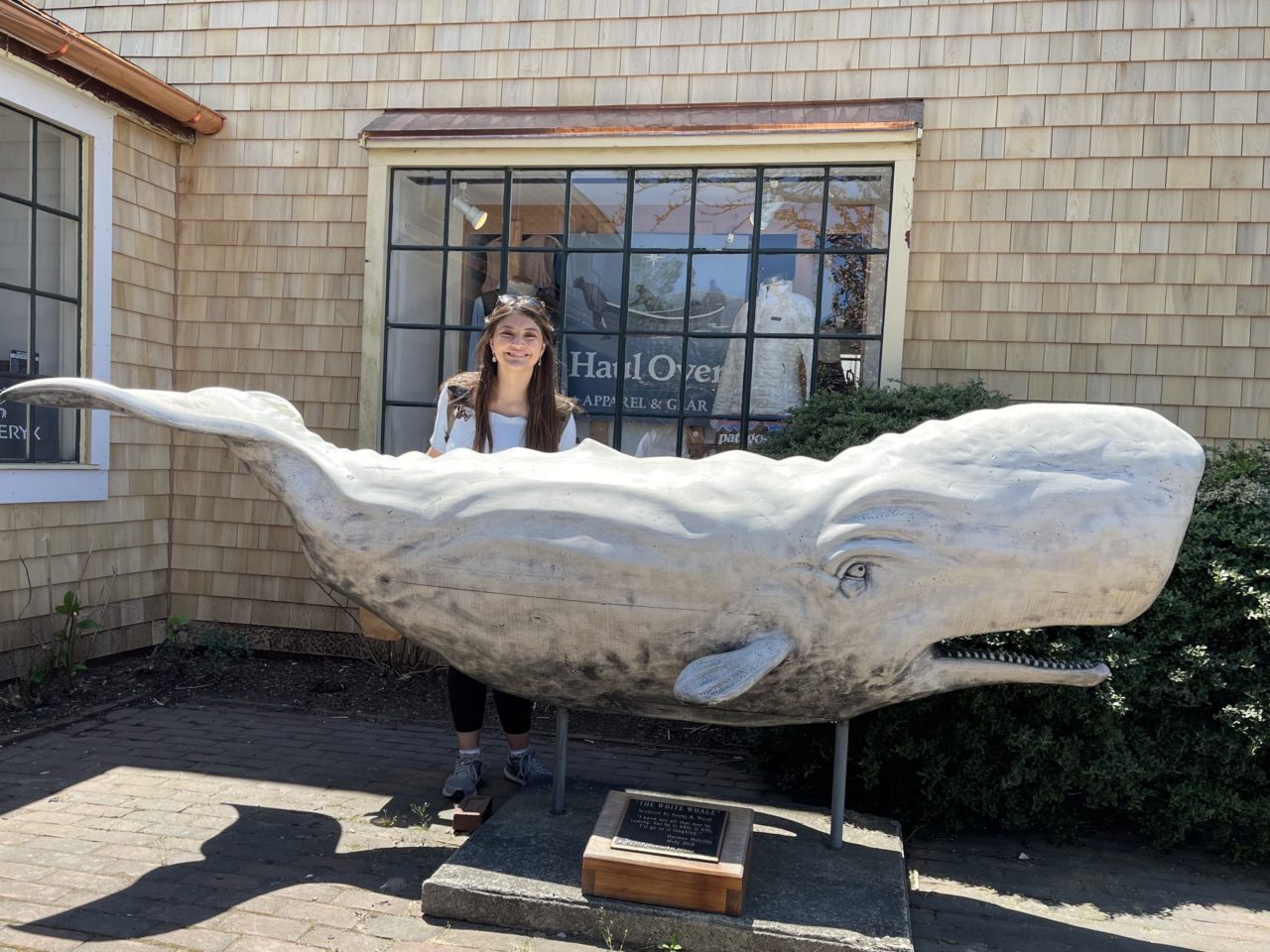 Marissa Garcia next to a sperm whale sculpture