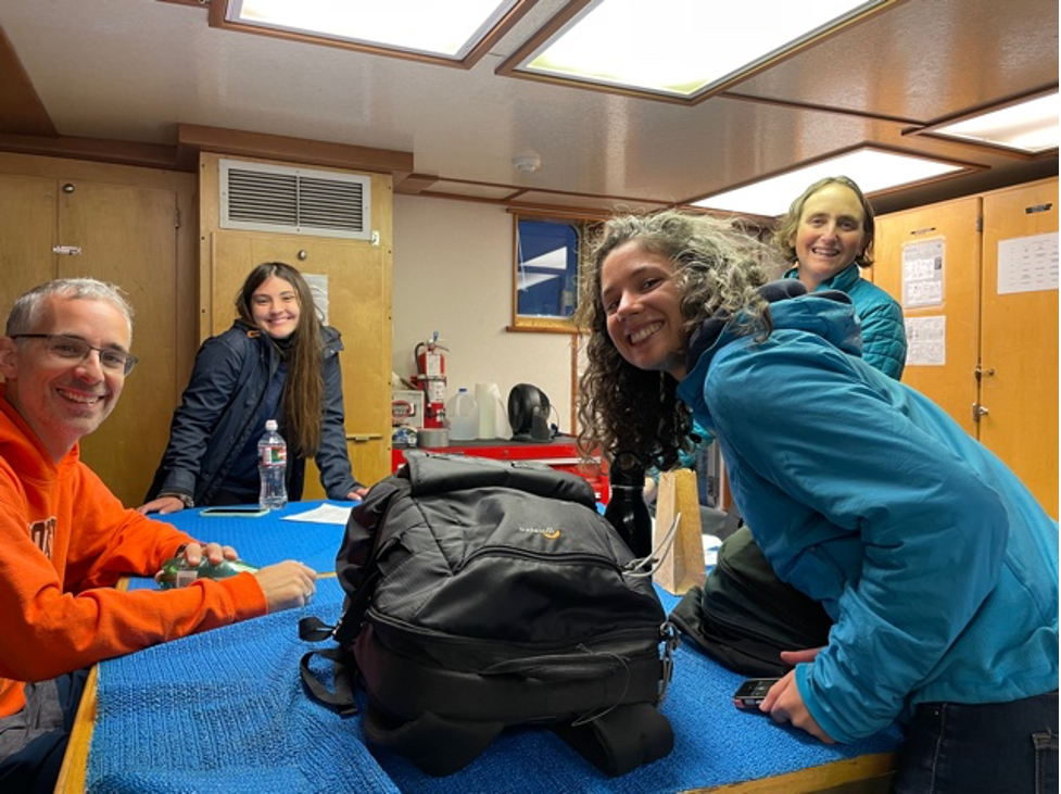 Figure 3. The research lab room on the R/V Pacific Storm with four eager scientists just as team HALO departed Yaquina Bay; from the left Holger Klinck, Marissa Garcia, Rachel Kaplan & Leigh Torres. Photo: Miranda Mayhall.