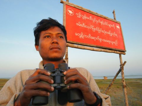 Conservationist Ren Noe Soe with binoculars near Nan Thar Island, Myanmar.