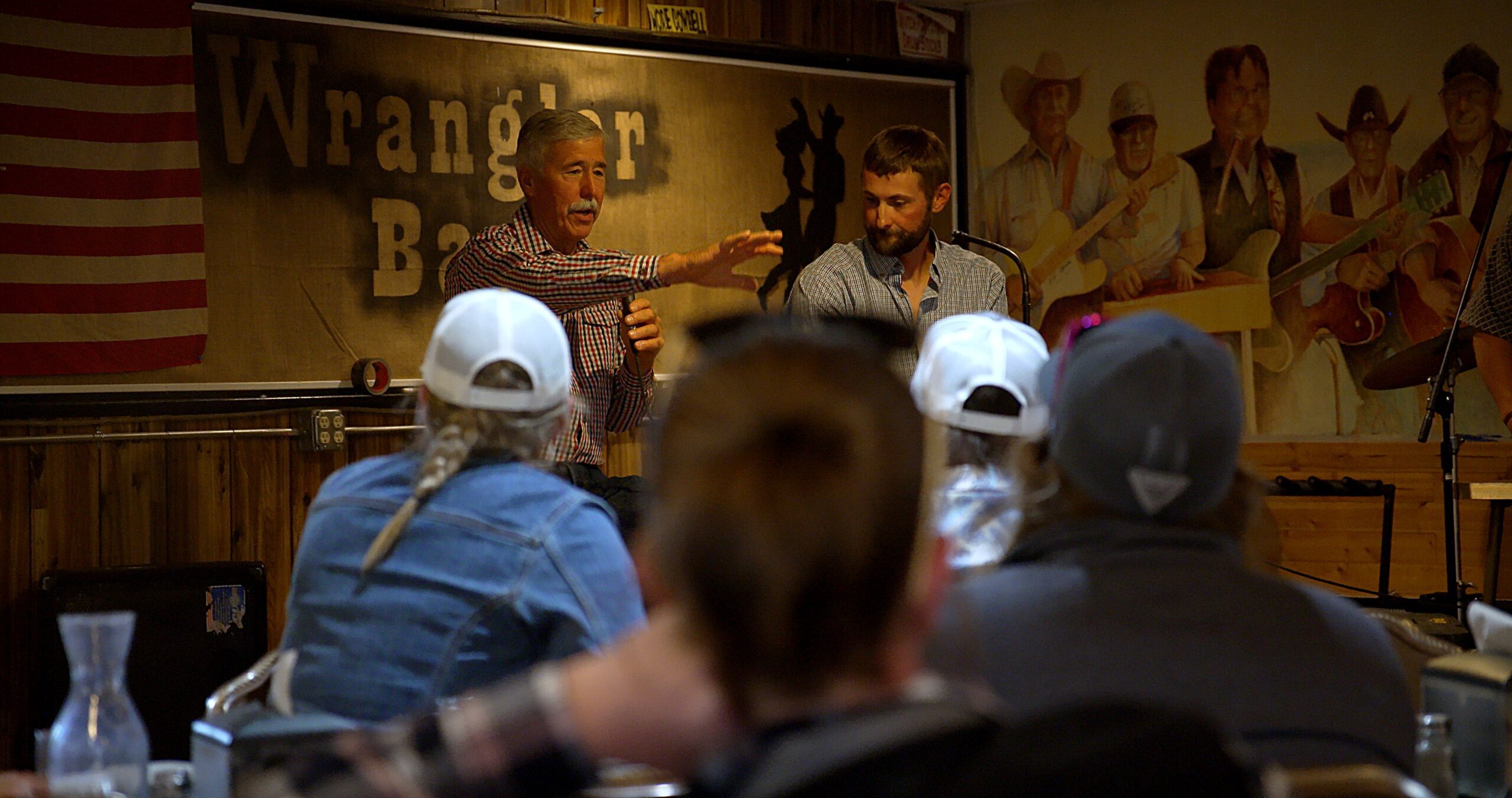 Two ranchers talking in front of others