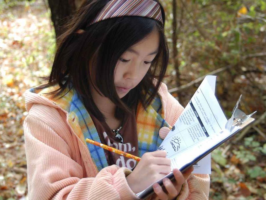 girl recording notes outside. photo courtesy of CLO