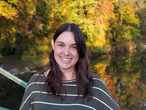 Kristin Brunk (postdoctoral fellow) stands with autumn foliage in background