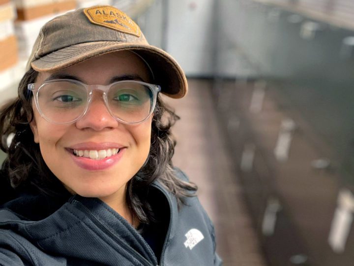Female stands in a lab, postdoctoral fellow Glaucia Cristina Del-Rio