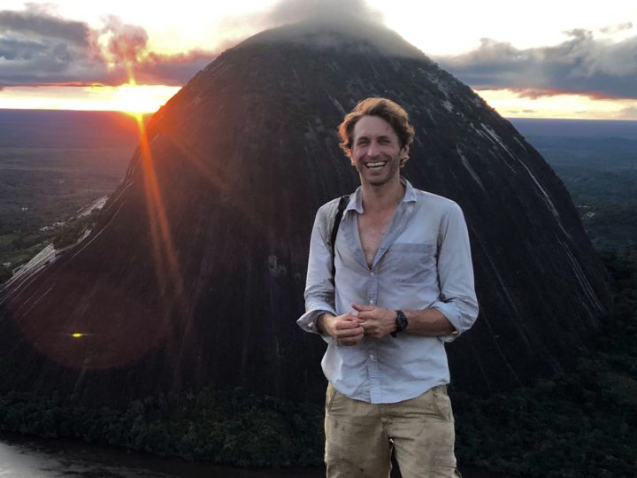Man pictured in front of a mountain and sunset. Glenn F. Seeholzer in photo.