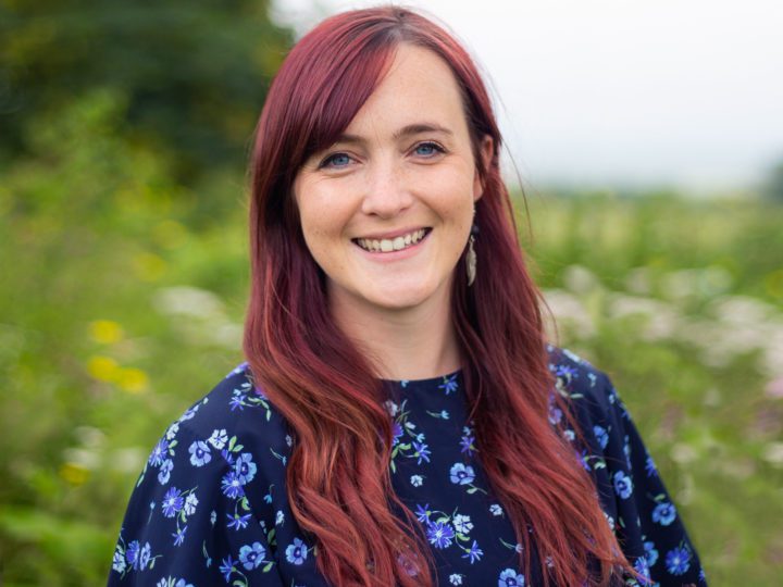 Red-haired lady in a meadow, staff member Kristy Lauder