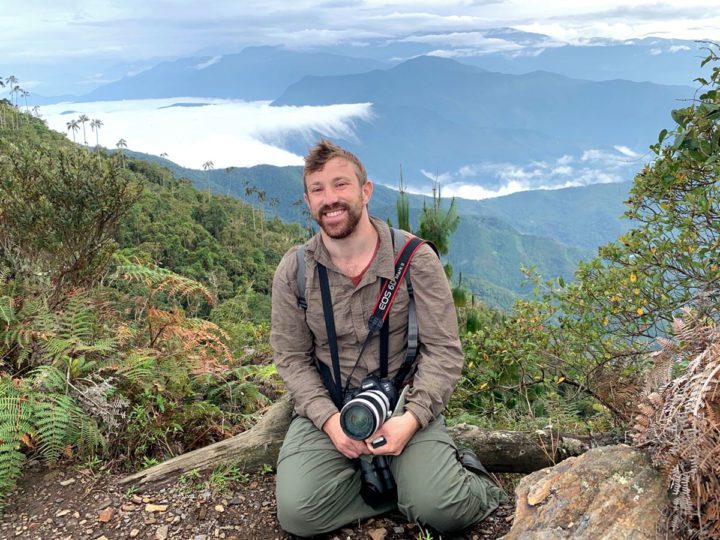 Staff member Ben Gottesman sits in front of a mountain view.