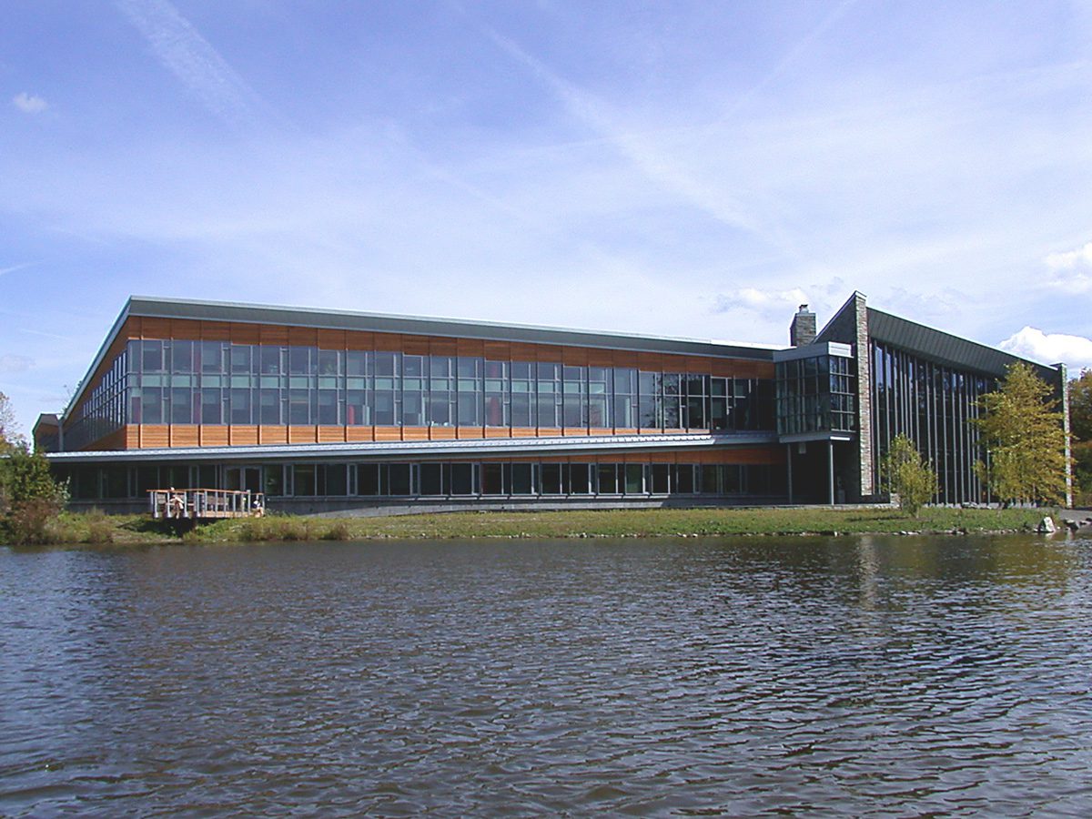 Big building next to water with a blue sky.