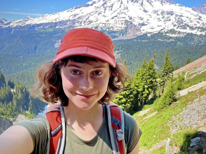 Girl in front of mountain scenery.