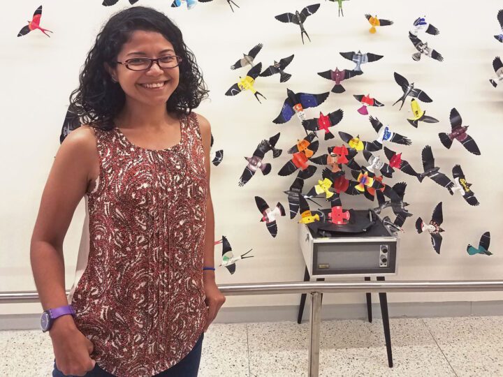 Girl stands with bird artwork