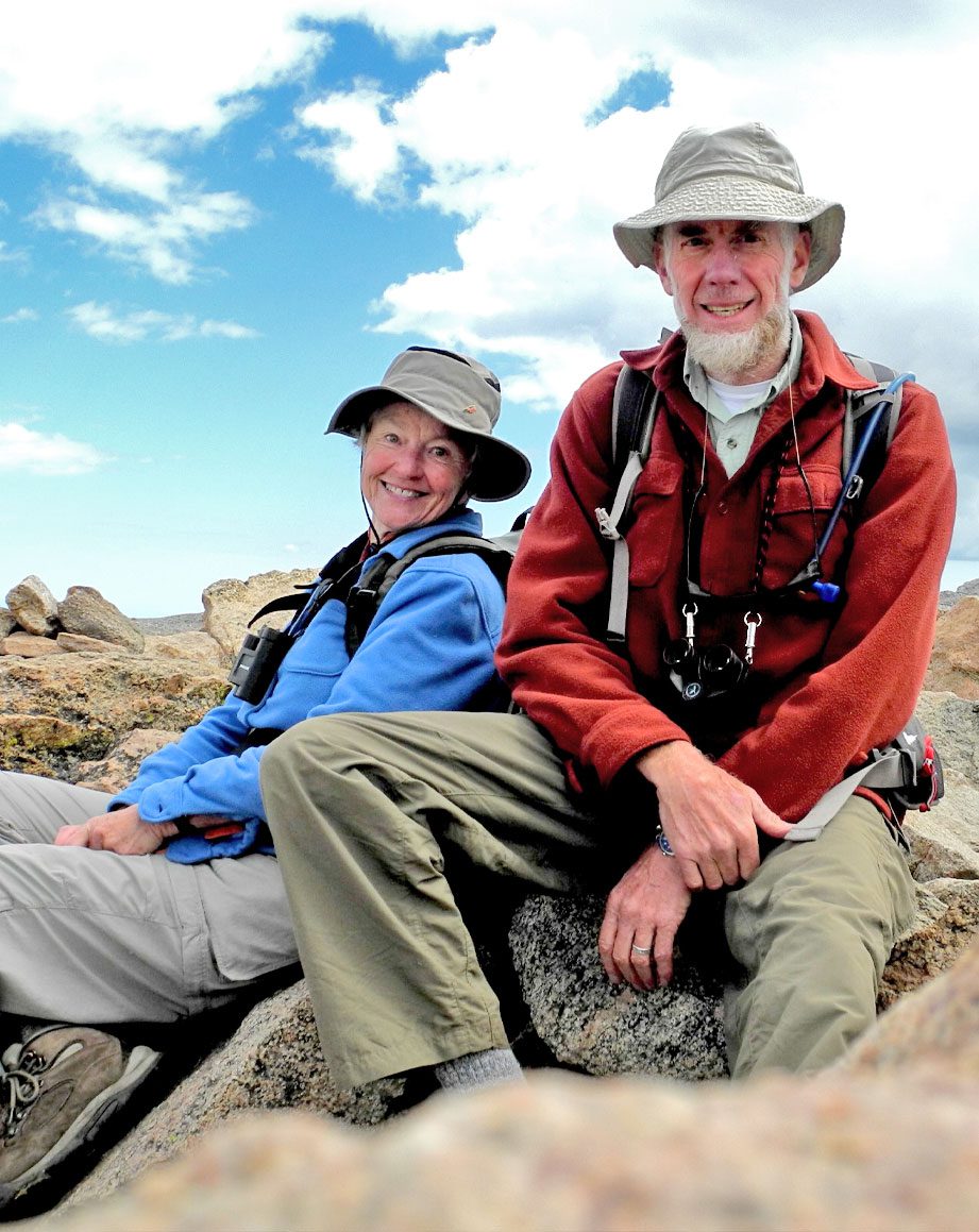 Older man and woman sitting on a rock.