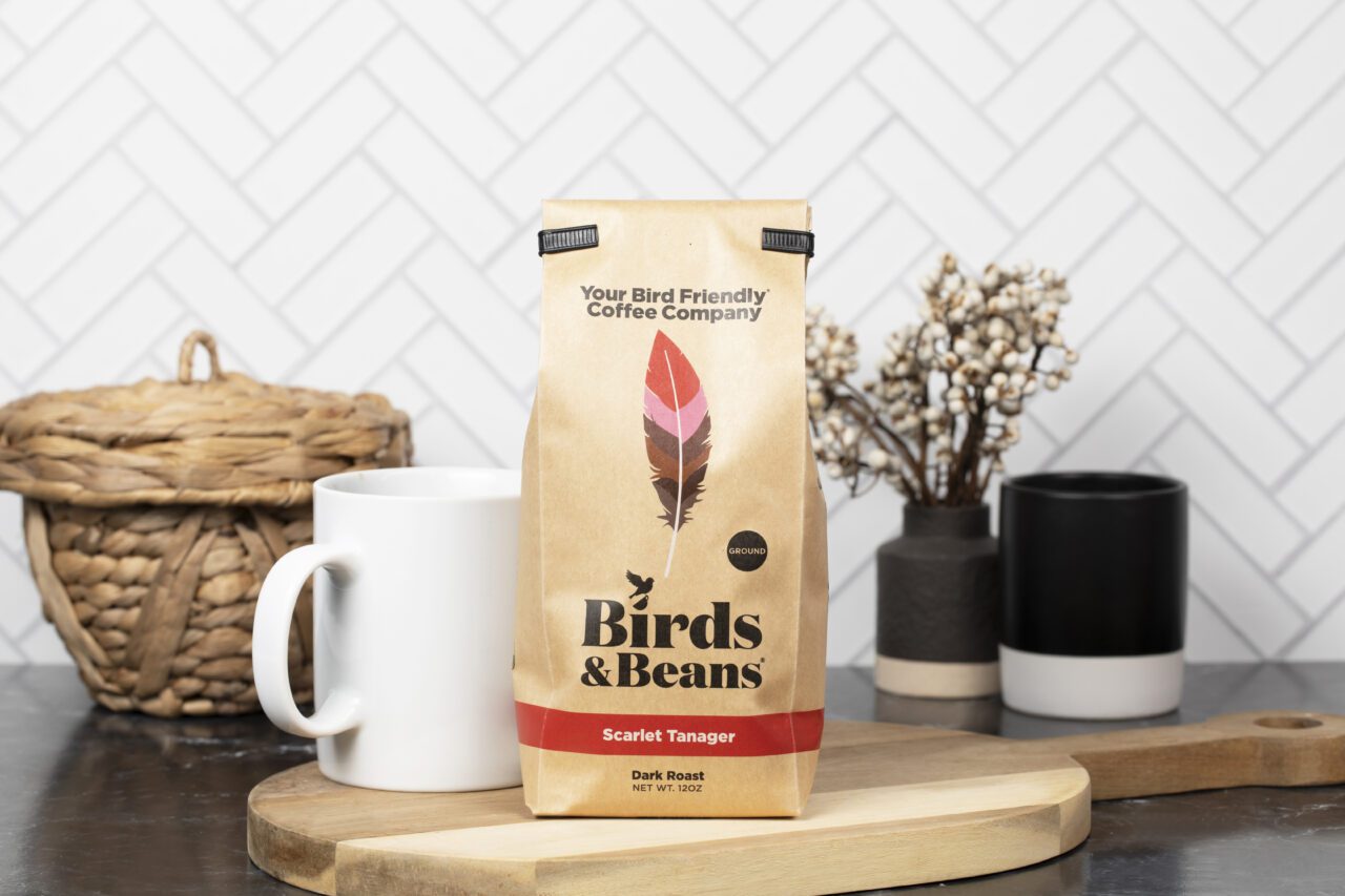 A countertop with a coffee cup and a bag of Birds and Beans coffee