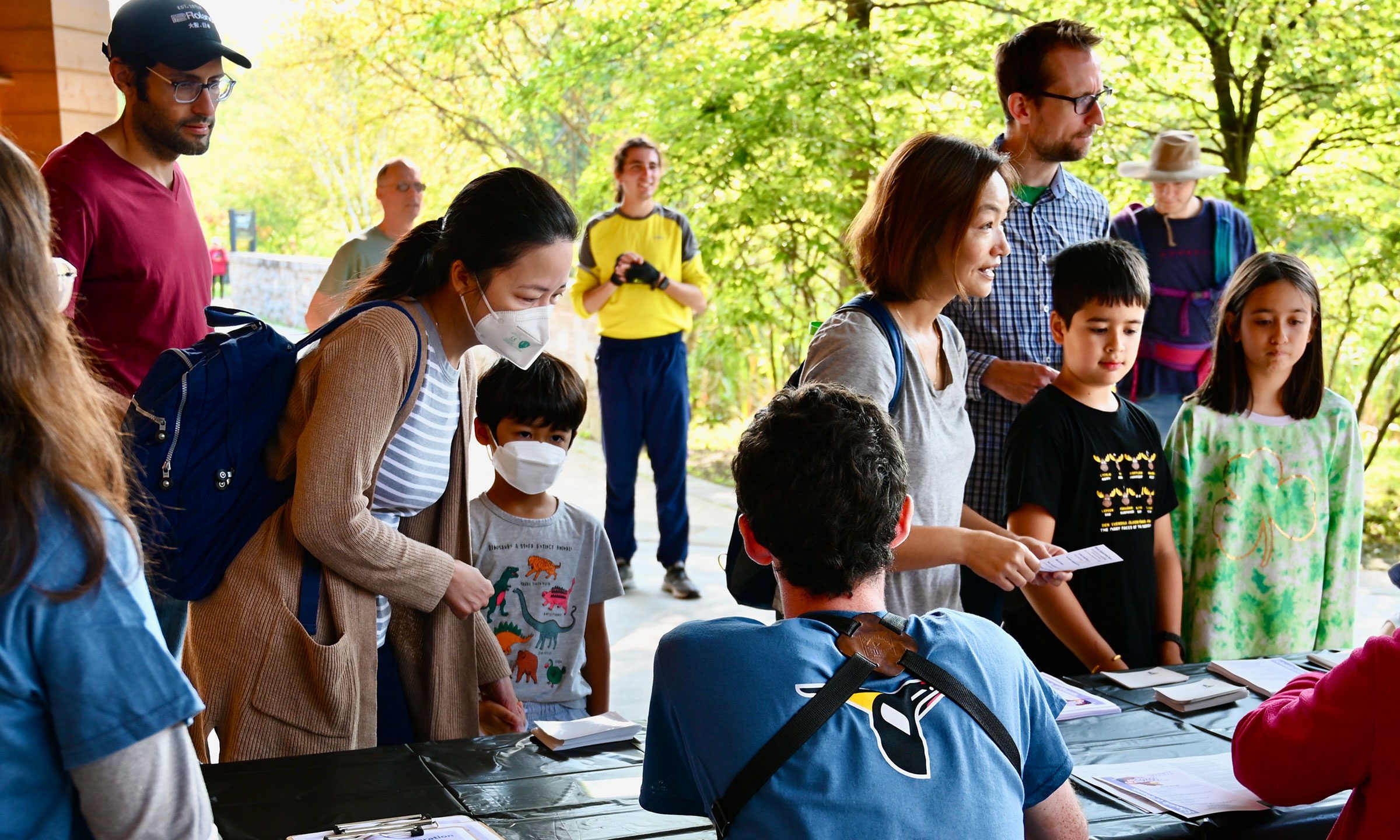 Visitors wait at a table with Lab staff