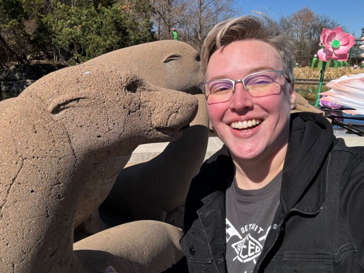 Smiling woman with a stone statue
