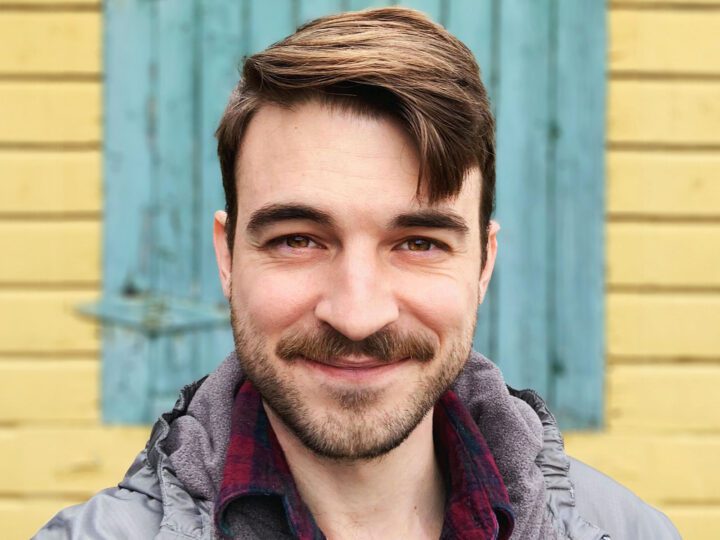 Smiling, bearded, young man.