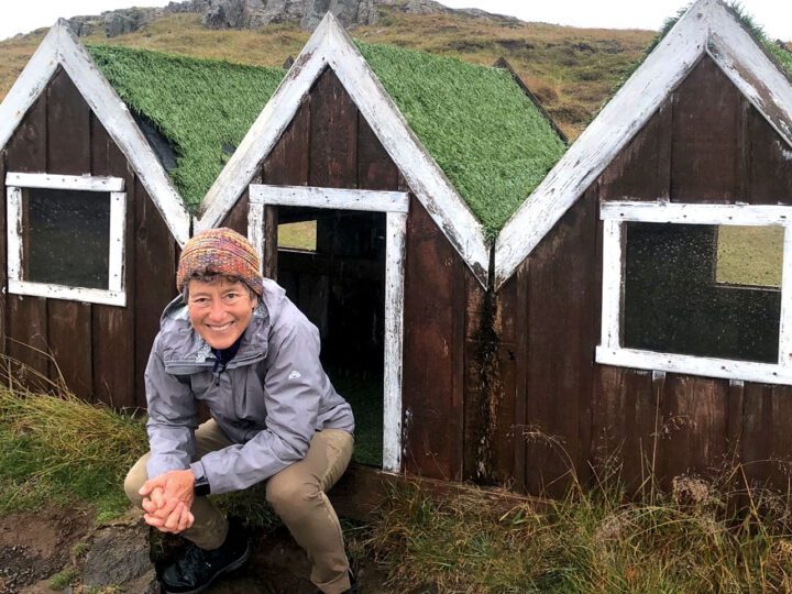 woman in front of mini houses on a landscape.