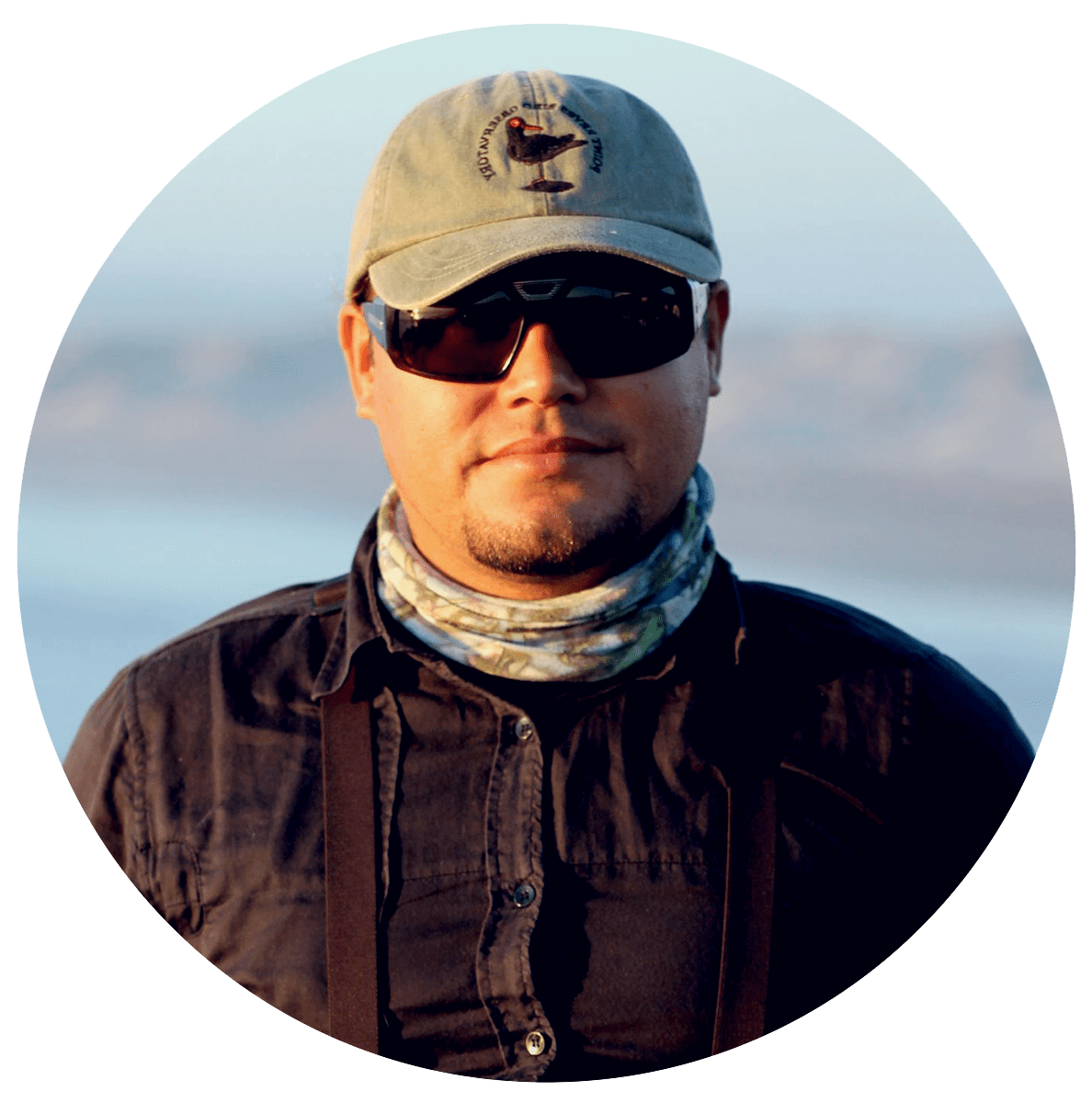Man with dark sunglasses and a cap.