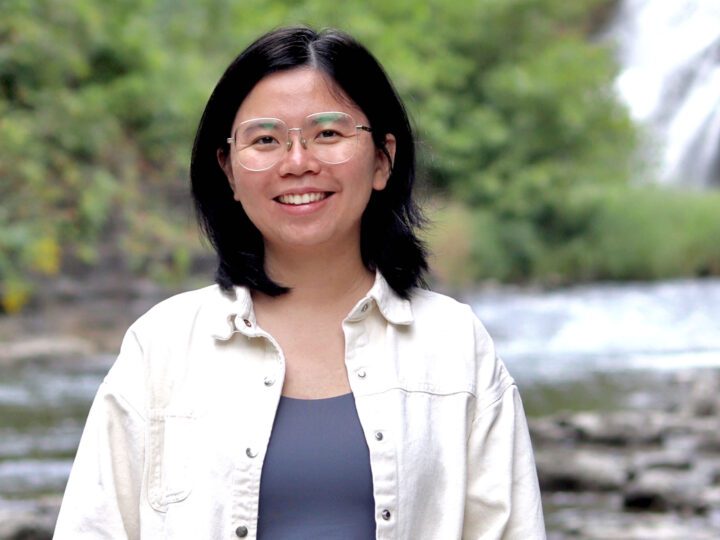 SMiling woman with glasses in front of a waterfall