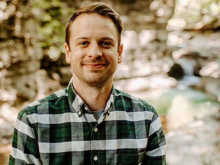 a man with brown hair smiles at the camera