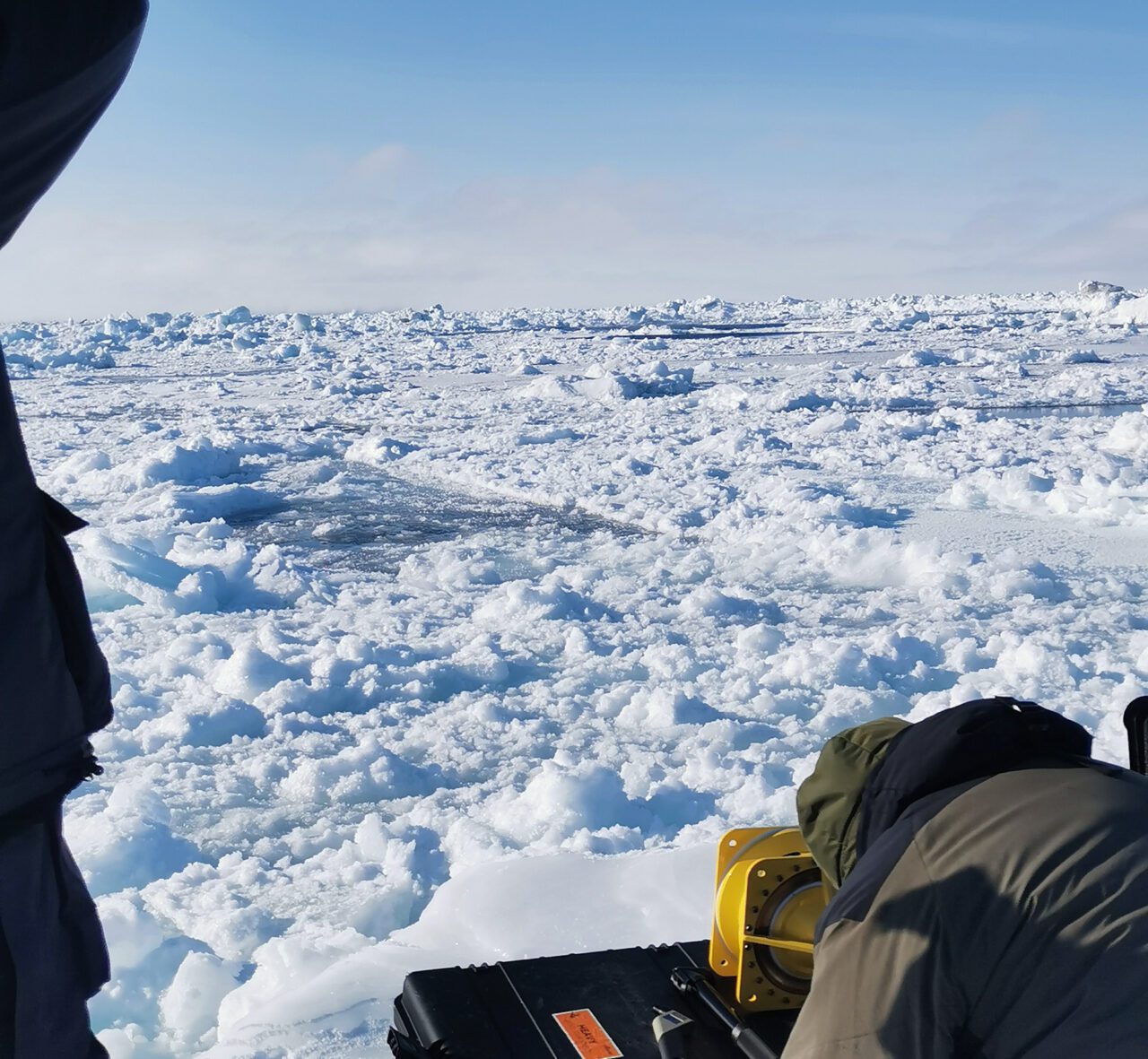 Person working with equipment on an icy landscape