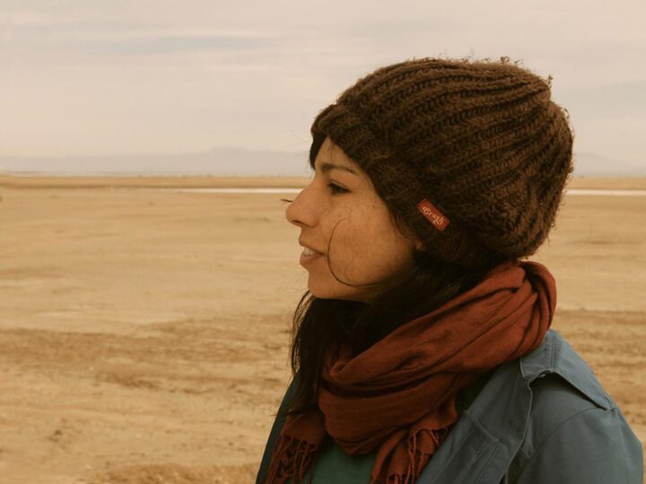 Amaranta posing in profile with a landscape in the background.