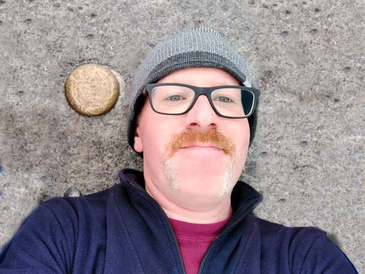 Jeremy leaning against a rock, looking at the camera