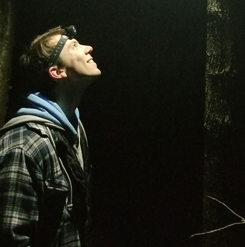 John Deitsch illuminated by an outdoor light at night