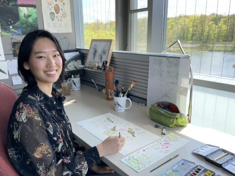 Vera painting at desk