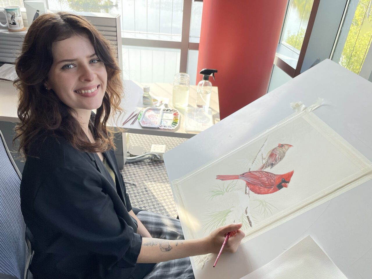 Lauren painting cardinals at desk