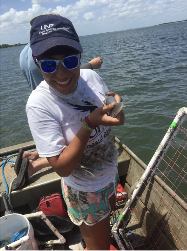 Triana Arguedas Álvarez, a panelist at our Conservation Career Day, 2021 holding a baby shark on a boat.