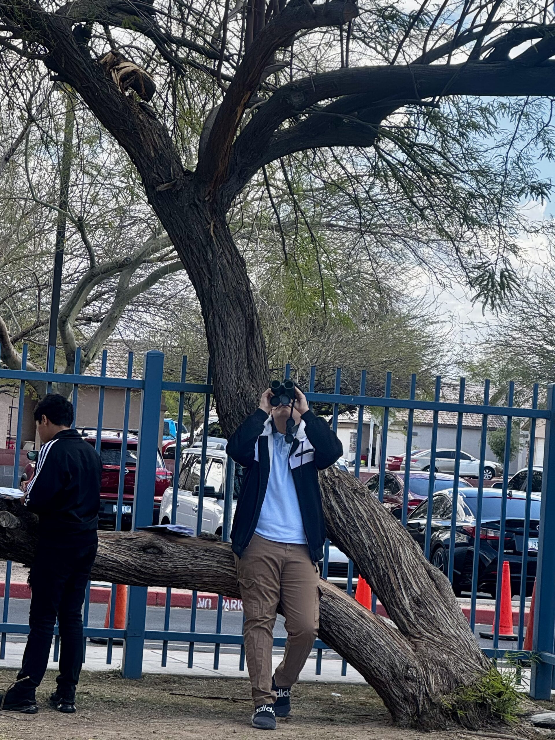 A student looks through a pair of binoculars.