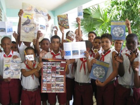 A group of youth hold up educational materials
