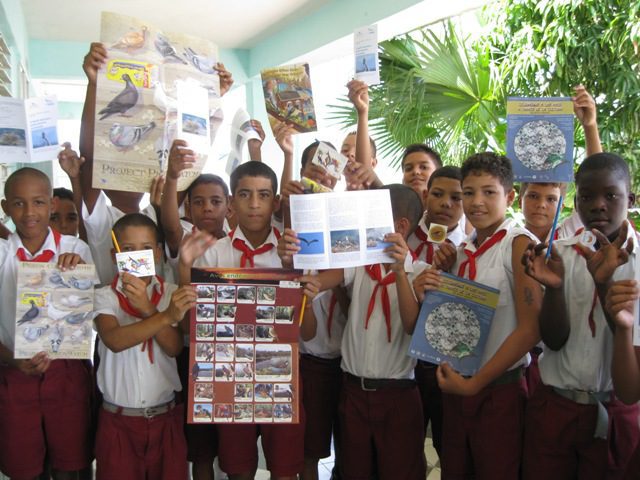 Un grupo de jóvenes sostiene materiales educativos.