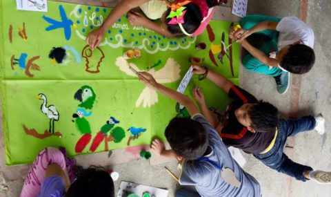 Kids painting birds on a poster