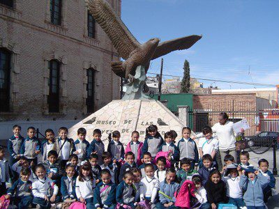 A group of youth in front of a statue of a Golden Eagle at the Museum of Birds in Mexico
