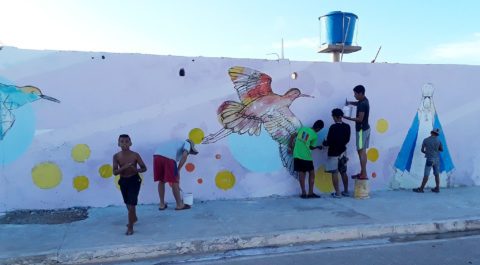 People painting a bird mural