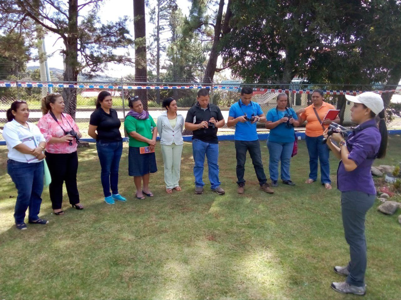 A group of people listen to a woman speak
