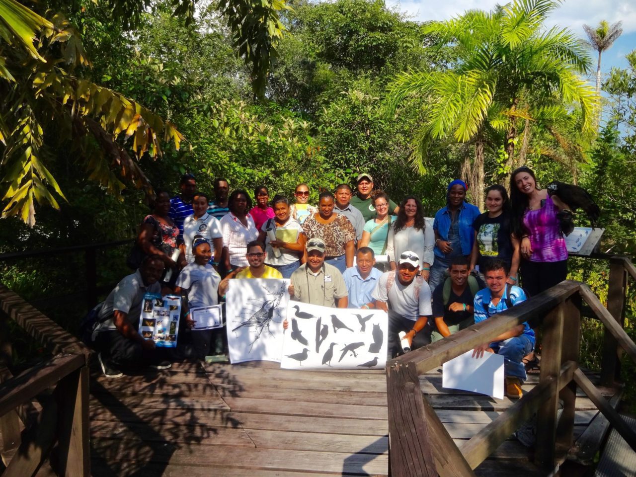 A group of people hold bird posters.