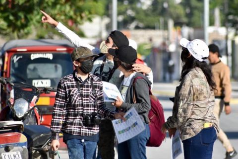 Niño apuntando al cielo con un grupo de personas