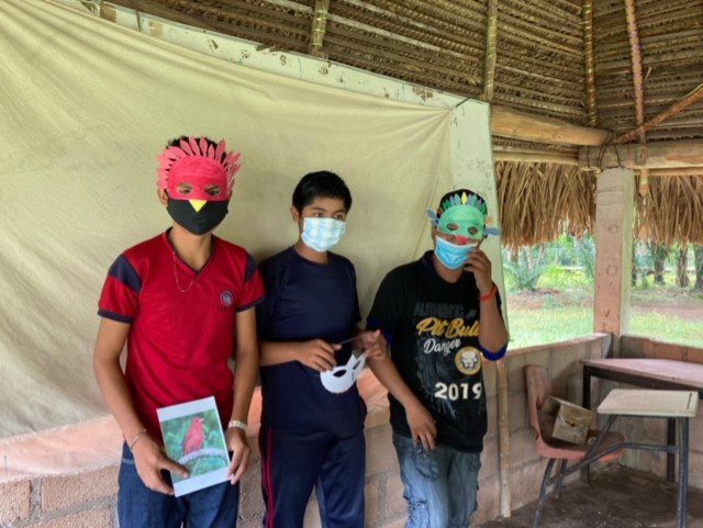 three young boys wearing colorful paper masks