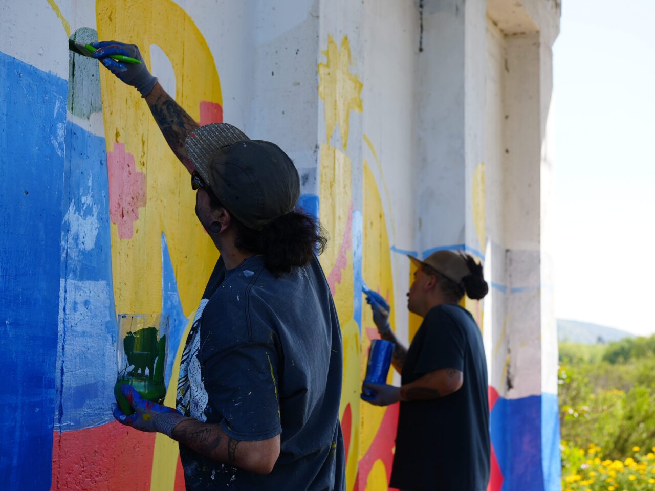 Two people painting a mural