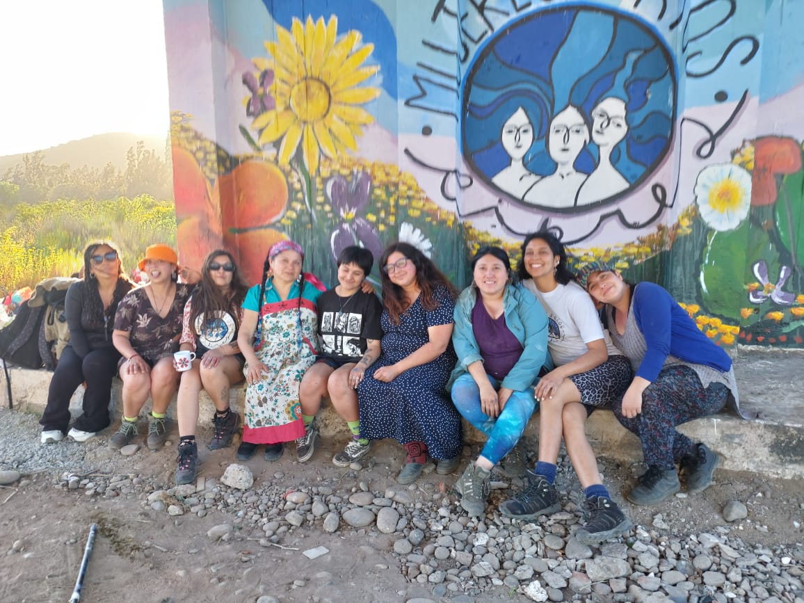A group of women in front of a mural