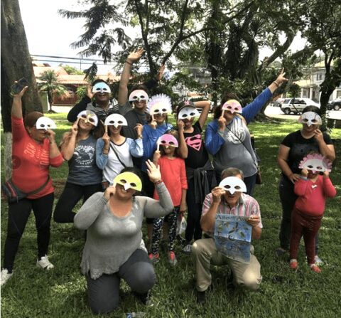 Participantes de edades diversas show their bird masks.